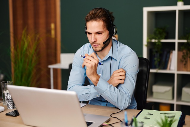 Analyst sitting in front of a laptop with headphones on